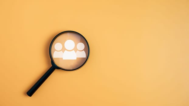 Customer group icons in a magnifying glass placed on a yellow background represent the selection of business goals, target customers. Marketing plans and strategies, customer-centric strategies.