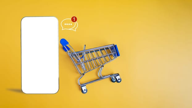 Shopping car and empty smartphone on yellow background. shopping online concept.