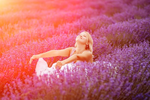 Woman lavender field. A middle-aged woman sits in a lavender field and enjoys aromatherapy. Aromatherapy concept, lavender oil, photo session in lavender.