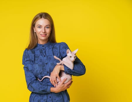 Mid-aged woman, dedicated cat lover, radiates happiness as lovingly holds content and happy cat in hands against yellow background. Deep bond between pet owner and cherished feline companion. High quality photo