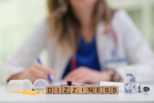A medical professional is writing notes on a patients dizziness, with medication and visual aids for reference