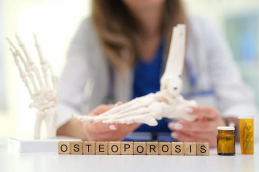 A closeup of a detailed osteoporosis study featuring skeletal models, alongside various medications and treatments