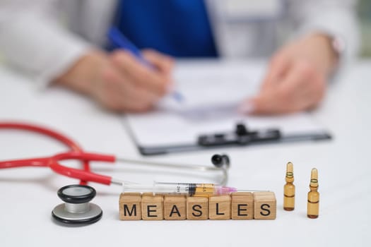 A doctor carefully documents the measles vaccination process, noting the syringes and vials used throughout