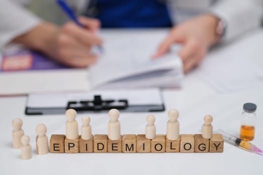 A detailed closeup of various epidemiology themes featuring wooden figures which emphasize public health initiatives