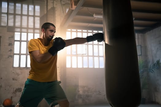 Fighter hits punching bag in a dark gym. High quality photo