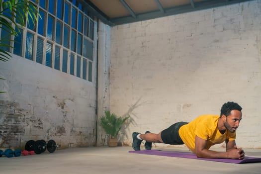 Muscular black man performing plank. Fitness workout concept. High quality photo
