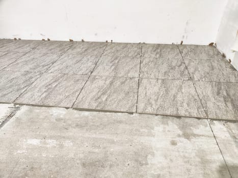 New tiles are laid out in an indoor area, highlighting the progress of a tile repair and installation project for home improvement.