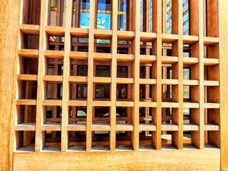 Detailed wooden lattice pattern featuring a space for text, showcasing craftsmanship under natural light, ideal for design projects.