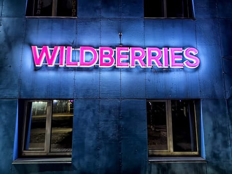 Kirov, Russia - November 19, 2024: Bright neon signage of an online store illuminates the exterior of a building, showcasing the brand's identity after dark.