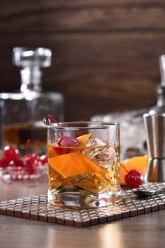 Cocktail Old Fashioned is an old-fashioned sophistication of whiskey and sweet syrup. Served with ice, orange zest and Maraschino cherry. 