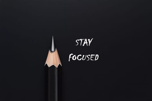 A sharpened pencil rests next to the message urging individuals to maintain their focus and dedication in their tasks.
