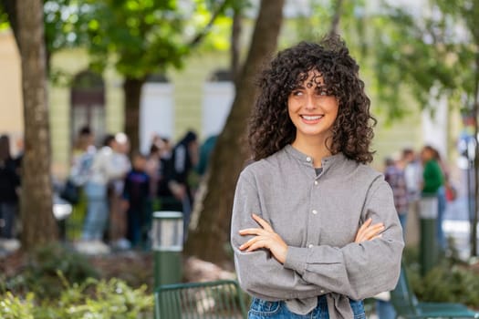 Portrait of happy Caucasian young woman smiling friendly, glad expression looking at side, resting, relaxation feel satisfied of good news outdoors. Lady girl on urban city street. Town lifestyles