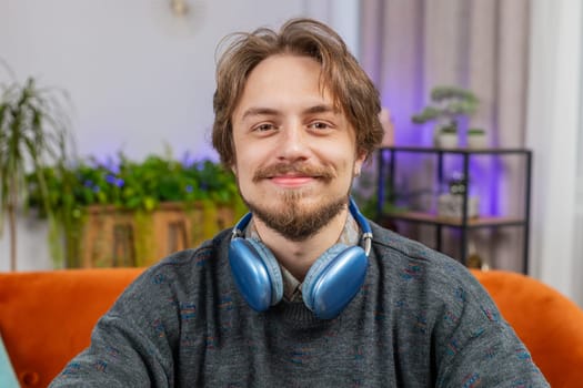 Close-up face portrait of happy calm man at home table smiling friendly, glad expression looking away dreaming resting, relaxation feel satisfied good news, celebrate win. Caucasian guy in office room