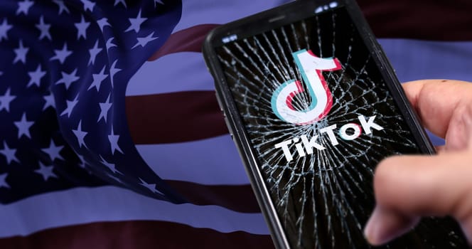 Washington, USA, Jan 18 2024; TikTok logo on a shattered smartphone screen against the American flag. Platform ban in the United States due to national security concerns.