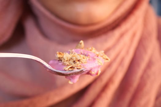 Closeup of creamy yogurt topped with crunchy granola, perfect for a delicious breakfast