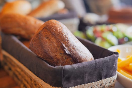 Warm brown bread rolls are served fresh in a woven basket for everyone to enjoy