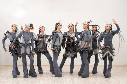 Group of young dancers in fantastic space costumes full-length isolated shot