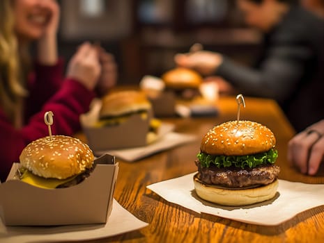 Juicy gourmet burgers with lettuce and cheese served on a wooden table, with blurred friends enjoying a meal in the background. The image represents social dining, fast food, and casual restaurant experiences.