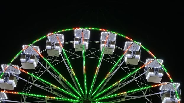 A brightly illuminated Ferris wheel against the night sky.