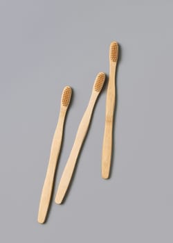 Three biodegradable bamboo toothbrushes on a light gray background top view, copy space. Zero waste and no plastic concept.
Natural personal accessories for tooth care, minimal style aesthetic flatlay