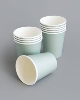 Light green paper disposable cup closeup isolated on grey. Template for graphics and advertising, mockup. Eco friendly, sustainable tableware. Zero plastic concept