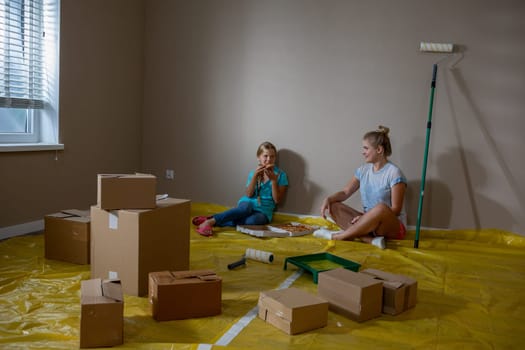 In a vibrant and newly painted room, two kids happily enjoy their playful time using colorful boxes around them