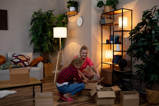 A vibrant scene of two people unpacking boxes in a stylish, modern living room filled with greenery.