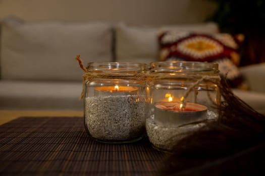 A tranquil and serene ambiance is beautifully created using lit candles housed in glass jars along with elegant decor