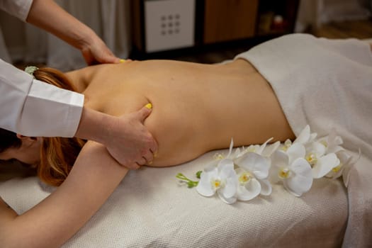 A tranquil massage therapy session showcasing a client immersed in relaxation amidst beautiful floral accents