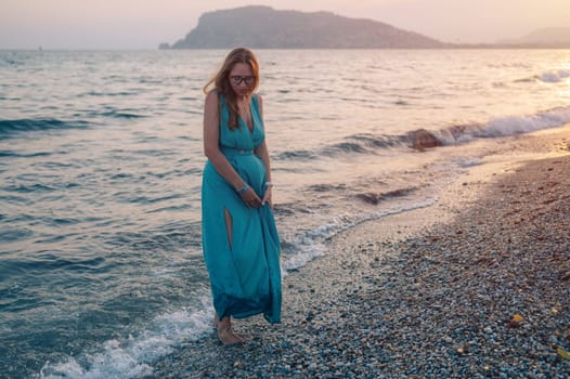 A woman in a flowing green dress poses on a pier by the sea at sunset, with a Turkey flag waving in the background.