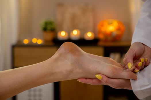 Immerse yourself in a soothing foot massage at a peaceful spa where soft candle lighting creates an ideal ambiance