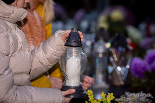 Participants gently hold stunning lanterns during a solemn candlelight vigil, beautifully surrounded by vibrant flowers