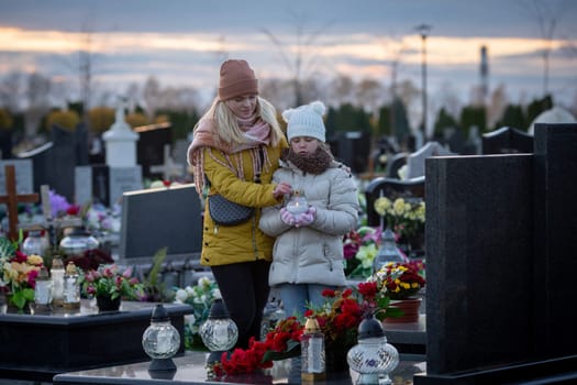 A profoundly touching and heartfelt moment between a mother and daughter at a cemetery, honoring their lost loved ones