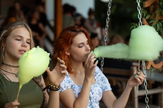 Two close friends joyfully enjoying cotton candy together, depicting a vibrant scene of happiness and youth
