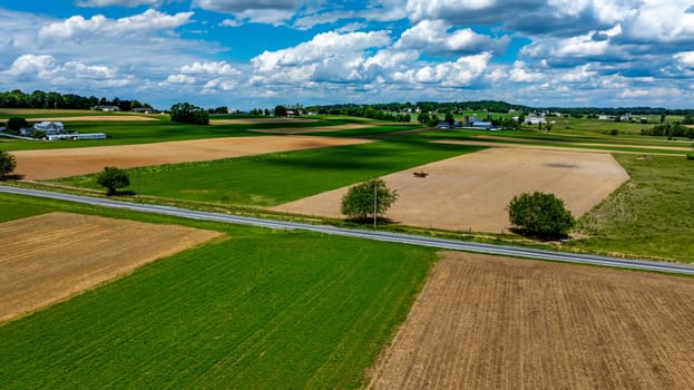 Vast agricultural fields dominate the landscape, showcasing a mix of green crops and brown earth.