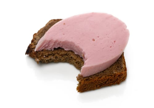 Bread with a creamy pink spread shows a bite taken out, inviting indulgence in a simple yet delightful treat.