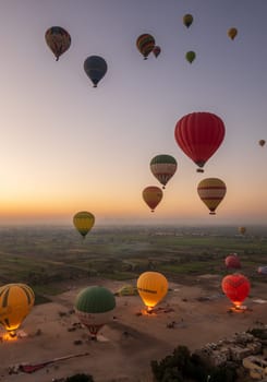 Luxor, Egypt - 31 October 2024: Many hot-air balloons over Sahara desert and Valley of Kings near Luxor, Egpyt