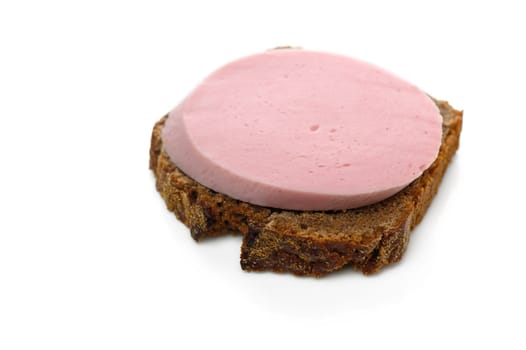 A slice of pink bologna on dark brown bread invites a tasty bite whenever hunger strikes.