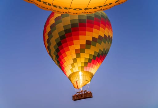 Large hot-air balloon rising from ground over Sahara desert and Valley of Kings near Luxor, Egpyt