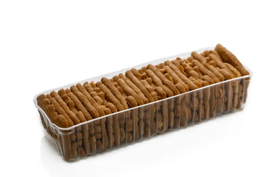 A long, clear container filled with golden-brown crispy snacks awaits to be enjoyed during a cozy gathering.