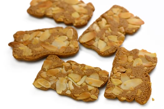 Five crunchy almond cookies are beautifully arranged, showcasing their golden-brown color and nutty topping.