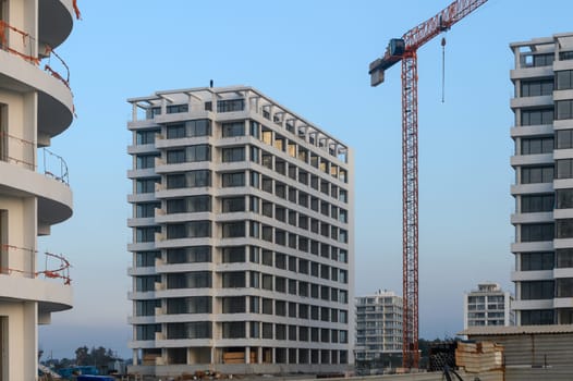 New residential buildings emerge against a twilight sky, showcasing modern architecture in an active construction zone.