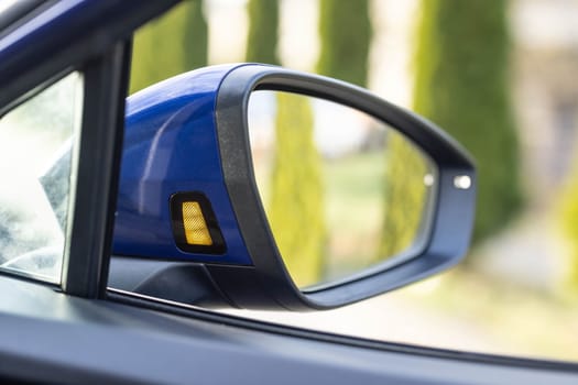 System blind spots of the car. Detail of side keeping assist system switch button. Blind zone monitoring sensor on the side mirror of a modern electric car.
