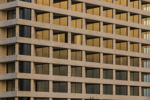 Elegant building structure reflects warm golden hues of sunset, creating a captivating urban landscape.