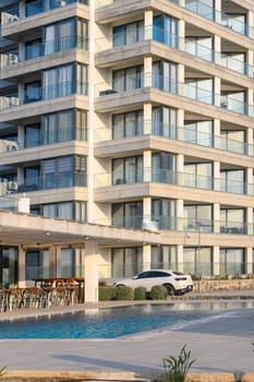 Modern hotel showcases sleek architecture with vibrant ambiance near the beach, inviting relaxation by the pool.