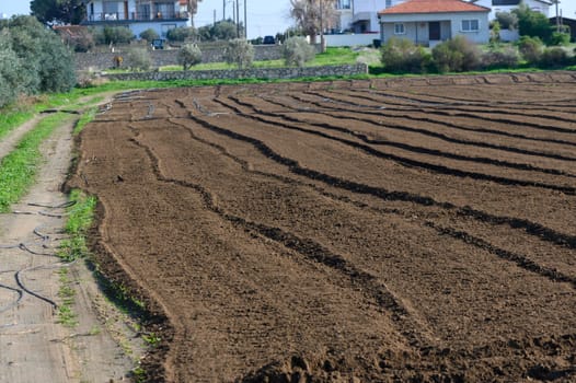 Fertile soil is prepared for planting as the sun shines down on peaceful rural fields.