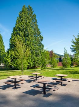 Small park with four tables and benches in a residential area.