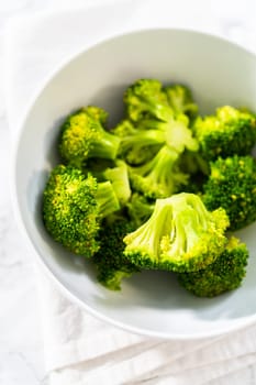 Freshly steamed broccoli in a white bowl.
