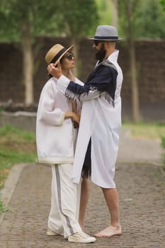 full length view of fashionable couple looking at camera outdoor.