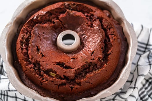 Cooling freshly baked red velvet bundt cake on a kitchen counter.